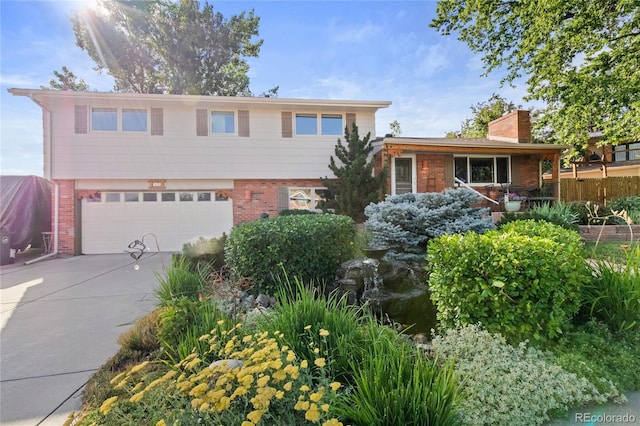 1615 Violet St, Golden, CO 80401 - split level home featuring brick siding, a garage, driveway, and a chimney
