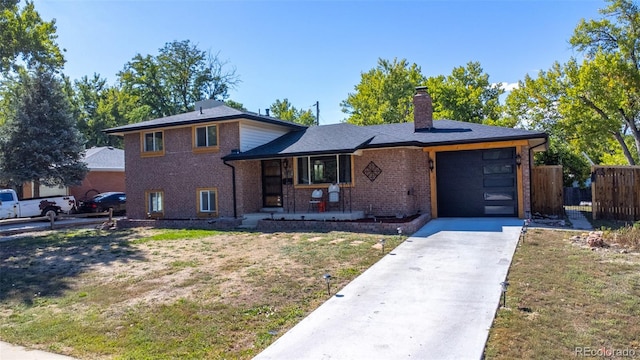 split level home featuring a front yard, a garage, and a porch