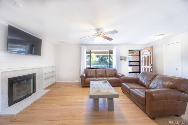 living room with light hardwood / wood-style floors and ceiling fan