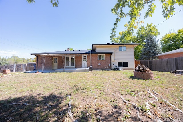 rear view of house with a patio and a yard