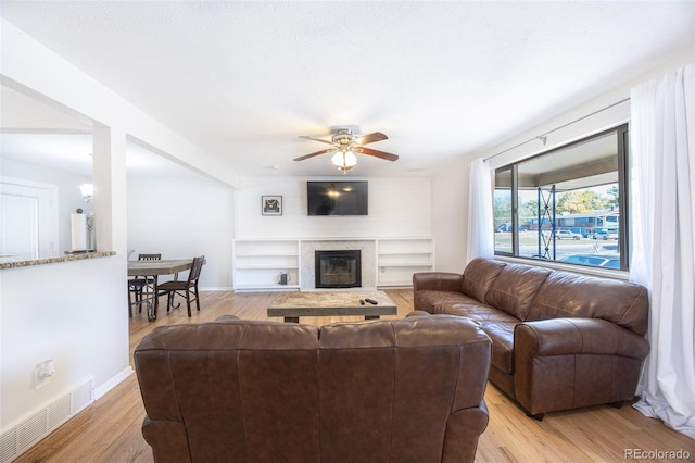 living room with light wood-type flooring and ceiling fan