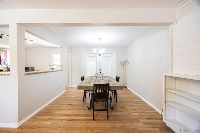 dining room with a notable chandelier and light hardwood / wood-style flooring