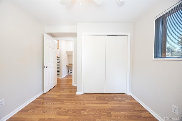 unfurnished bedroom with light hardwood / wood-style floors, ceiling fan, and a closet