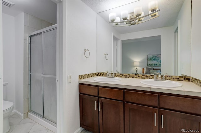 10966 W Half Moon Pass, Littleton, CO 80127 - full bath featuring toilet, a stall shower, double vanity, and backsplash