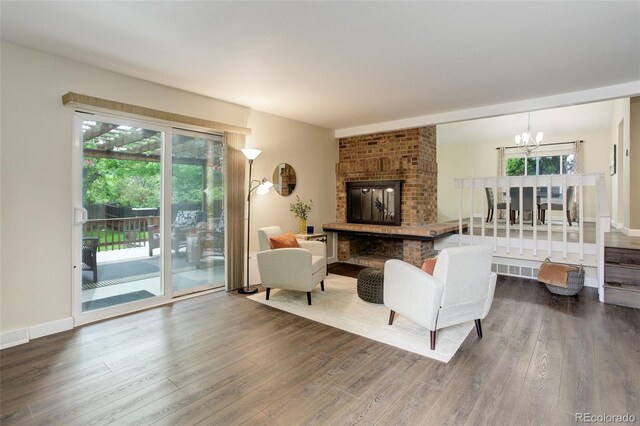 10966 W Half Moon Pass, Littleton, CO 80127 - living area featuring wood finished floors, a chandelier, and a brick fireplace
