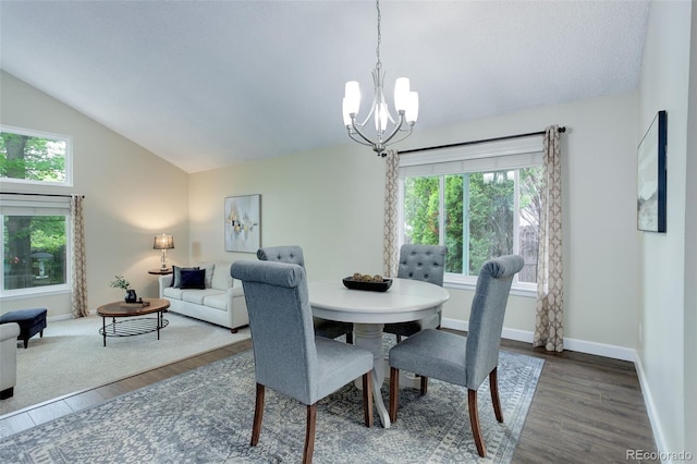 10966 W Half Moon Pass, Littleton, CO 80127 - dining space with a chandelier, vaulted ceiling, wood finished floors, and baseboards
