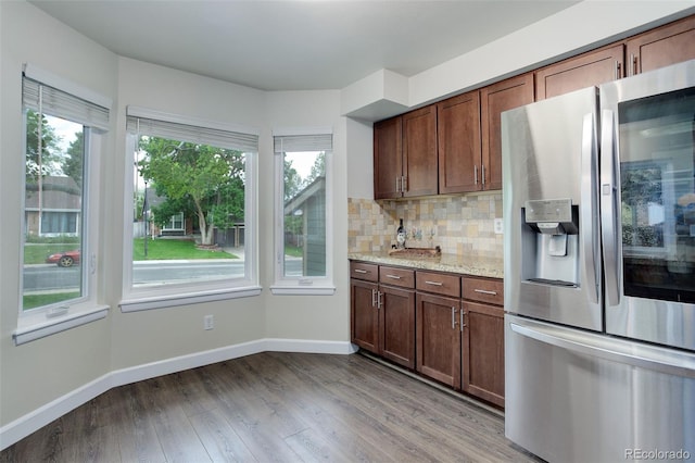 10966 W Half Moon Pass, Littleton, CO 80127 - kitchen featuring stainless steel fridge, light wood-style floors, baseboards, and decorative backsplash
