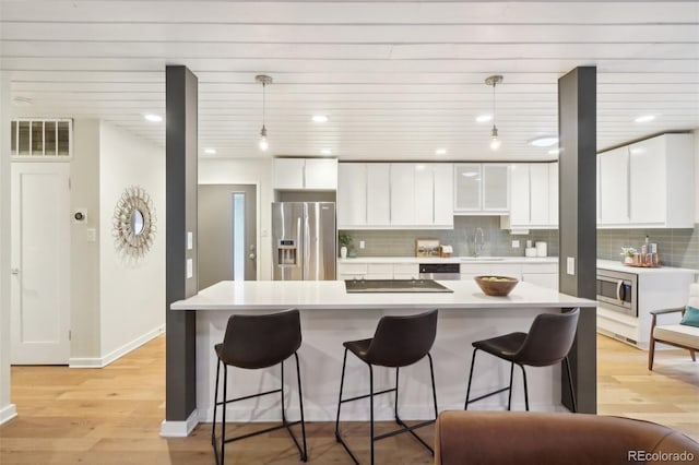 5405 S Lowell Blvd, Littleton, CO 80123 - kitchen with stainless steel appliances, a breakfast bar, backsplash, white cabinetry, and recessed lighting