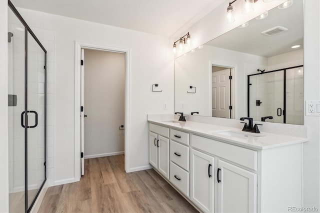 bathroom with vanity, hardwood / wood-style flooring, and an enclosed shower