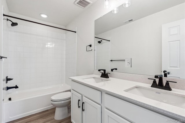 full bathroom featuring vanity, toilet, tiled shower / bath, and hardwood / wood-style flooring