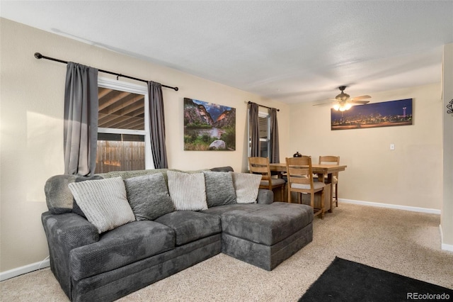 living room featuring a textured ceiling, light colored carpet, and ceiling fan