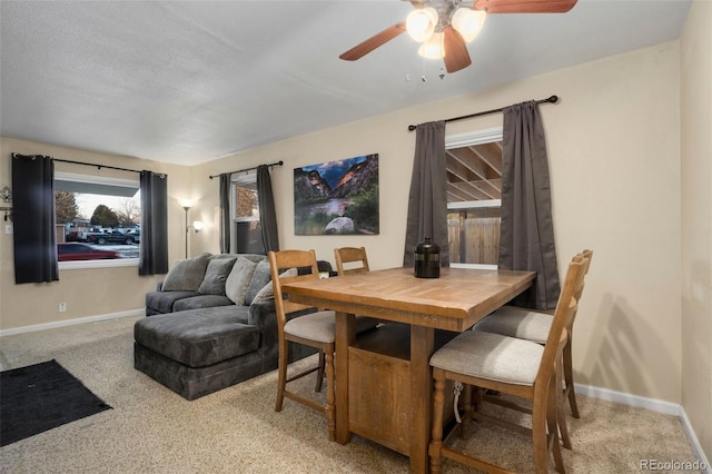 carpeted dining room with ceiling fan