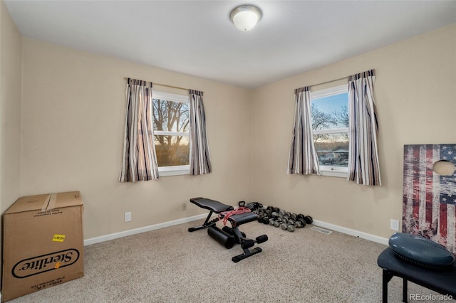 exercise room with carpet floors and a healthy amount of sunlight