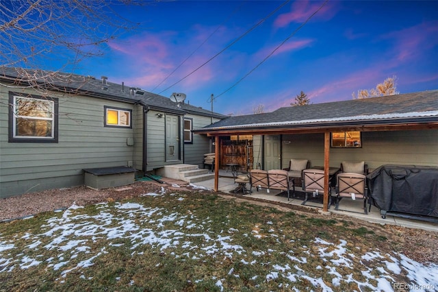 snow covered rear of property featuring a patio area