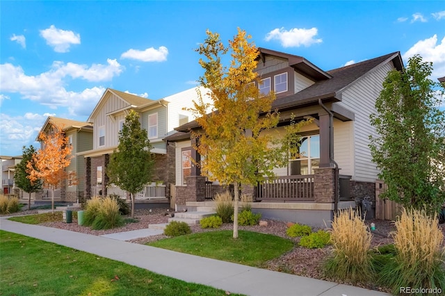 20968 E 60th Pl, Aurora, CO 80019 - craftsman-style home featuring stone siding, a porch, board and batten siding, and a front lawn
