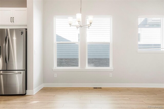 20968 E 60th Pl, Aurora, CO 80019 - unfurnished dining area featuring light wood-style flooring and a chandelier