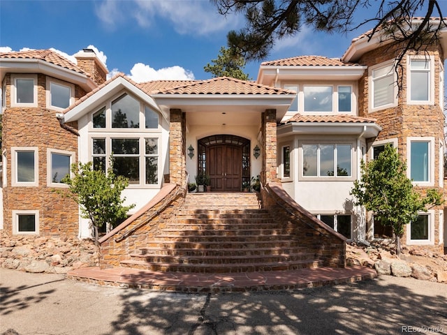 1189 Rembrandt Rd, Boulder, CO 80302 - mediterranean / spanish-style home with stucco siding, a chimney, stone siding, and stairs