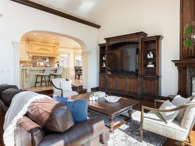 1189 Rembrandt Rd, Boulder, CO 80302 - living area featuring arched walkways, wood finished floors, crown molding, a high ceiling, and a high end fireplace