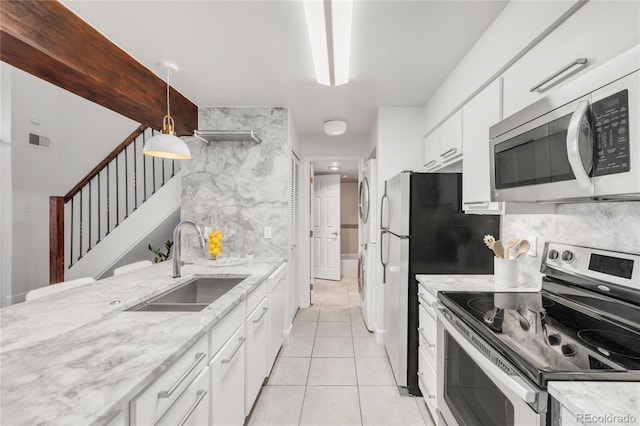 kitchen featuring visible vents, decorative backsplash, appliances with stainless steel finishes, white cabinetry, and a sink