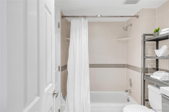 bathroom with shower / bath combo, visible vents, and toilet