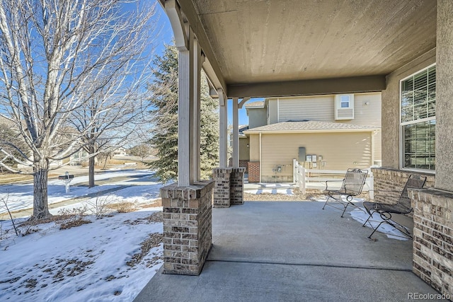 snow covered patio featuring covered porch