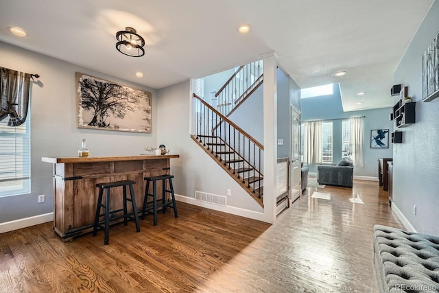 bar with dark hardwood / wood-style flooring