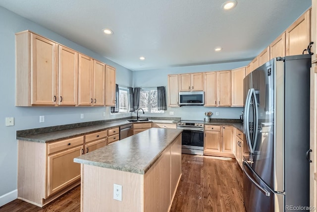 kitchen featuring stainless steel appliances, a kitchen island, and light brown cabinets