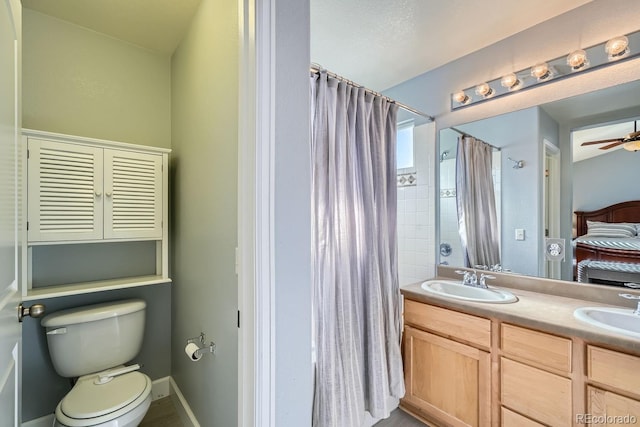 bathroom with vanity, walk in shower, ceiling fan, and toilet