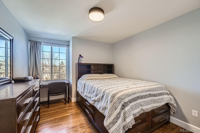 bedroom with hardwood / wood-style floors and a textured ceiling