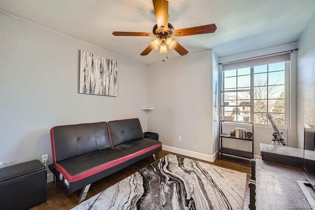 sitting room with ceiling fan, hardwood / wood-style floors, and a textured ceiling