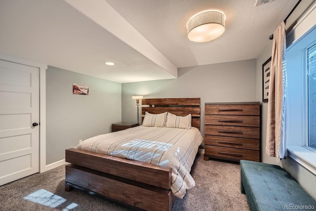 bedroom with dark colored carpet and a textured ceiling