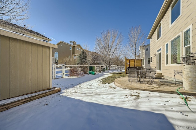 yard covered in snow featuring a patio