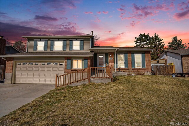 split level home featuring brick siding, driveway, an attached garage, and a front yard