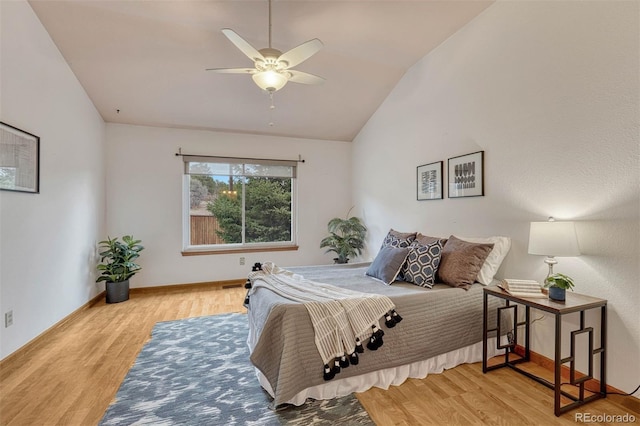 bedroom featuring wood finished floors, ceiling fan, baseboards, and lofted ceiling