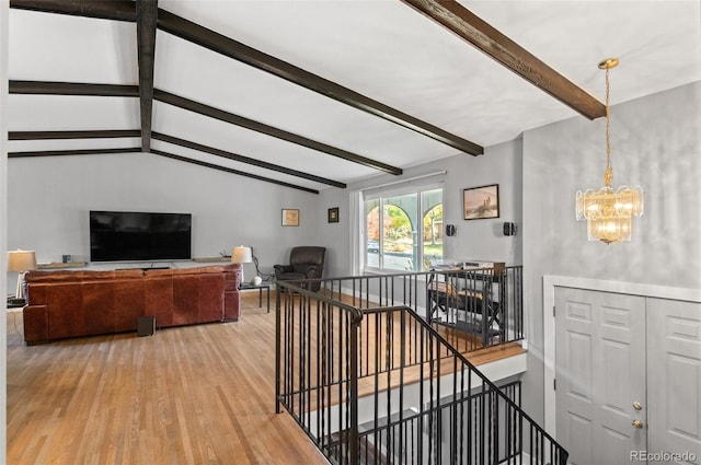 interior space featuring vaulted ceiling with beams, a notable chandelier, and wood-type flooring