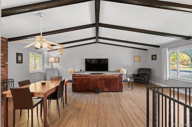 dining space with ceiling fan, vaulted ceiling with beams, light hardwood / wood-style floors, and plenty of natural light