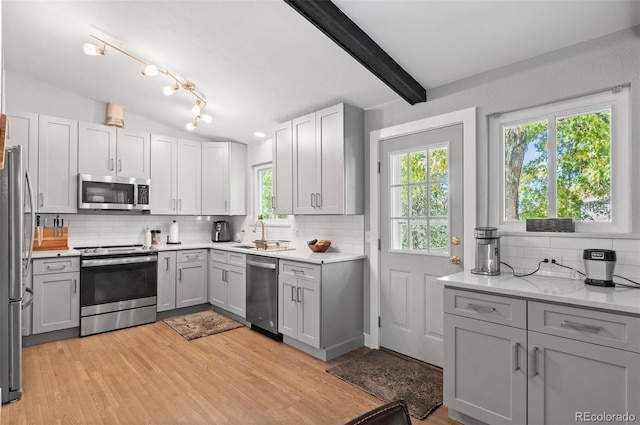 kitchen featuring appliances with stainless steel finishes, decorative backsplash, and plenty of natural light