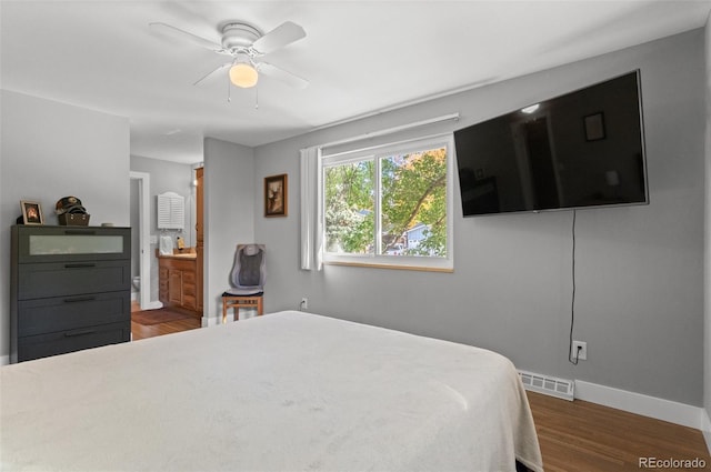 bedroom featuring dark wood-type flooring, ensuite bathroom, and ceiling fan