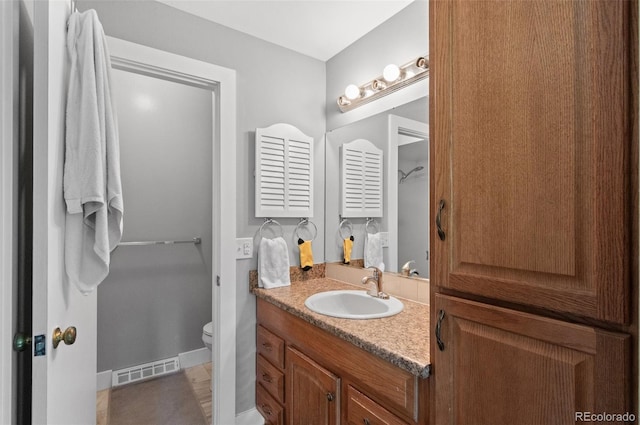 bathroom featuring toilet and vanity