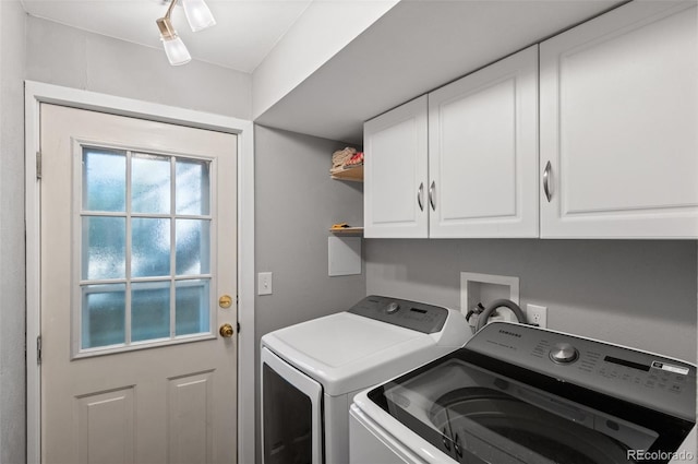 washroom with cabinets and washer and dryer