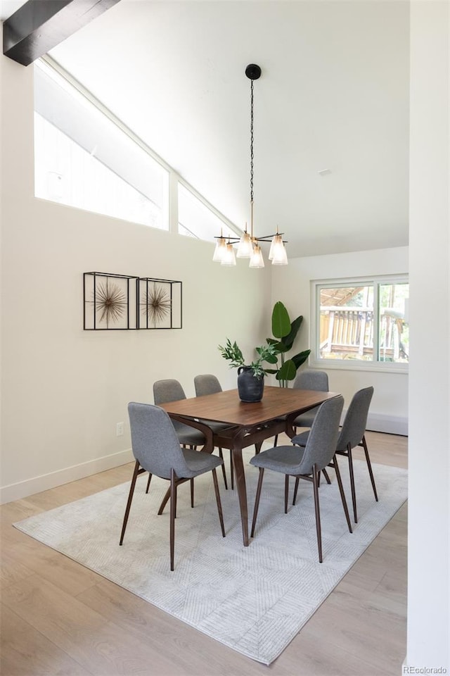 7453 E Jefferson Dr, Denver, CO 80237 - dining space with light wood finished floors, high vaulted ceiling, and a chandelier
