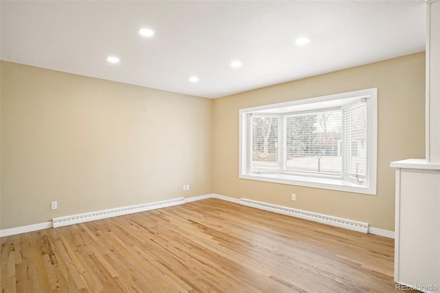 spare room with a baseboard radiator and light hardwood / wood-style floors