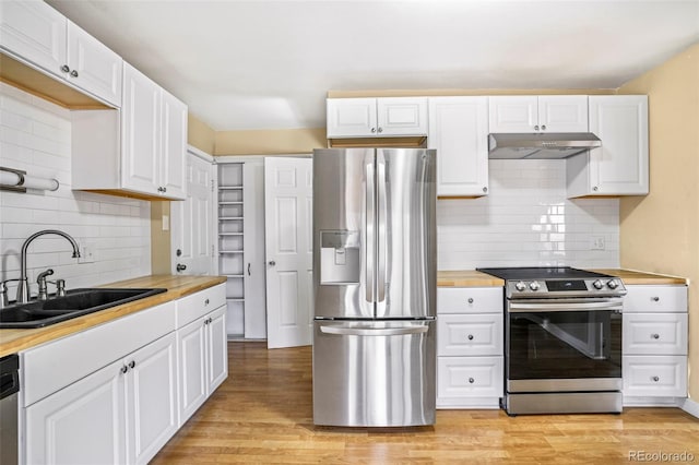 kitchen featuring sink, stainless steel appliances, wood counters, decorative backsplash, and white cabinets