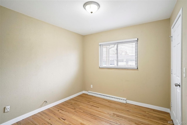 spare room with light wood-type flooring and baseboard heating