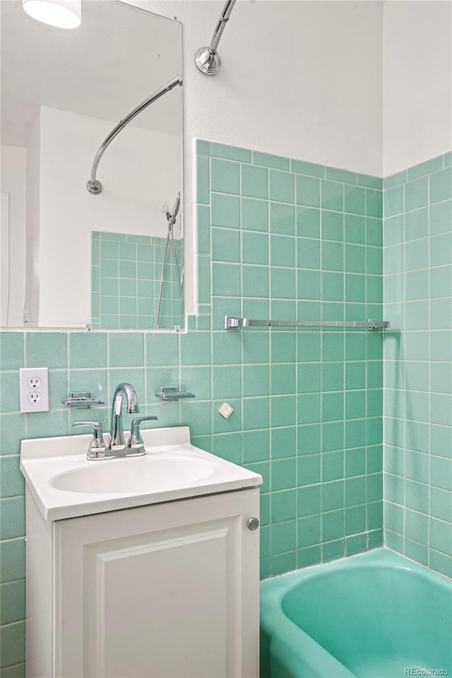 bathroom featuring backsplash, shower / tub combination, vanity, and tile walls