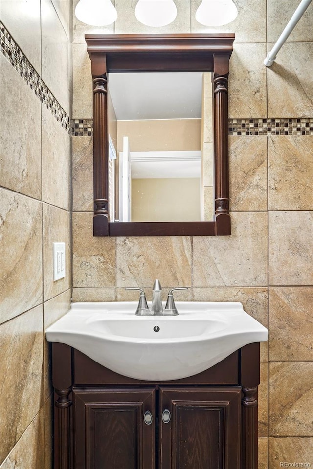 bathroom with vanity and tile walls