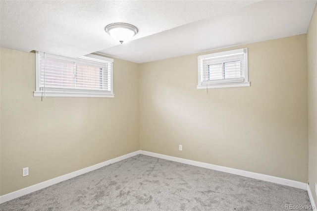 basement featuring light colored carpet and a textured ceiling