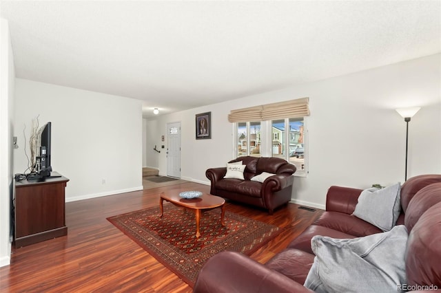 living area featuring wood finished floors, visible vents, and baseboards