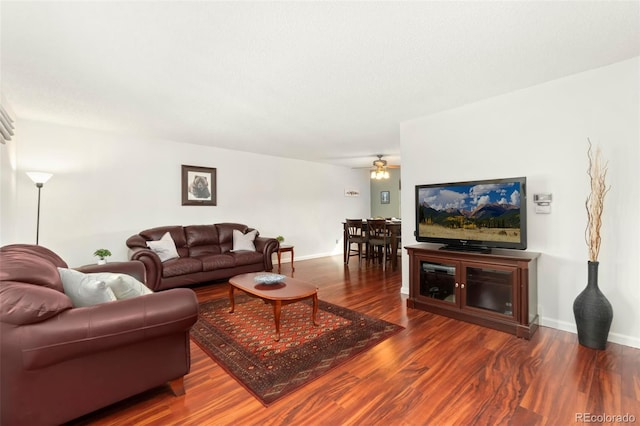 living area with a ceiling fan, baseboards, and wood finished floors