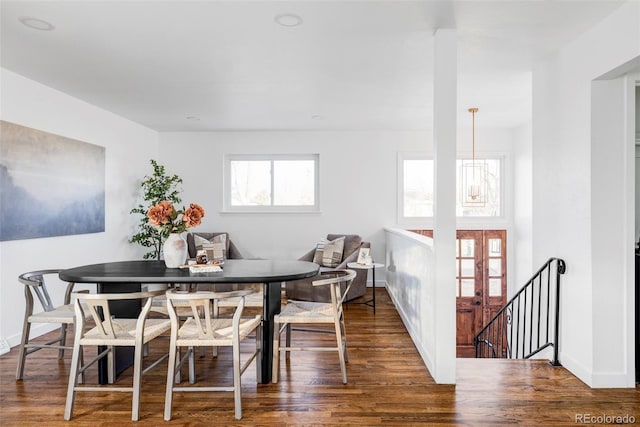 dining room with dark wood-type flooring and an inviting chandelier